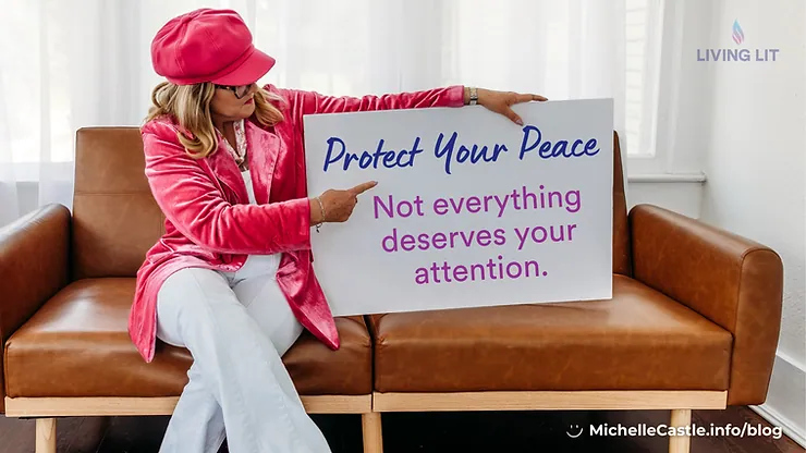 Michelle in pink hat and jacket sits on a brown couch holding a sign: Protect Your Peace, Not everything deserves your attention.